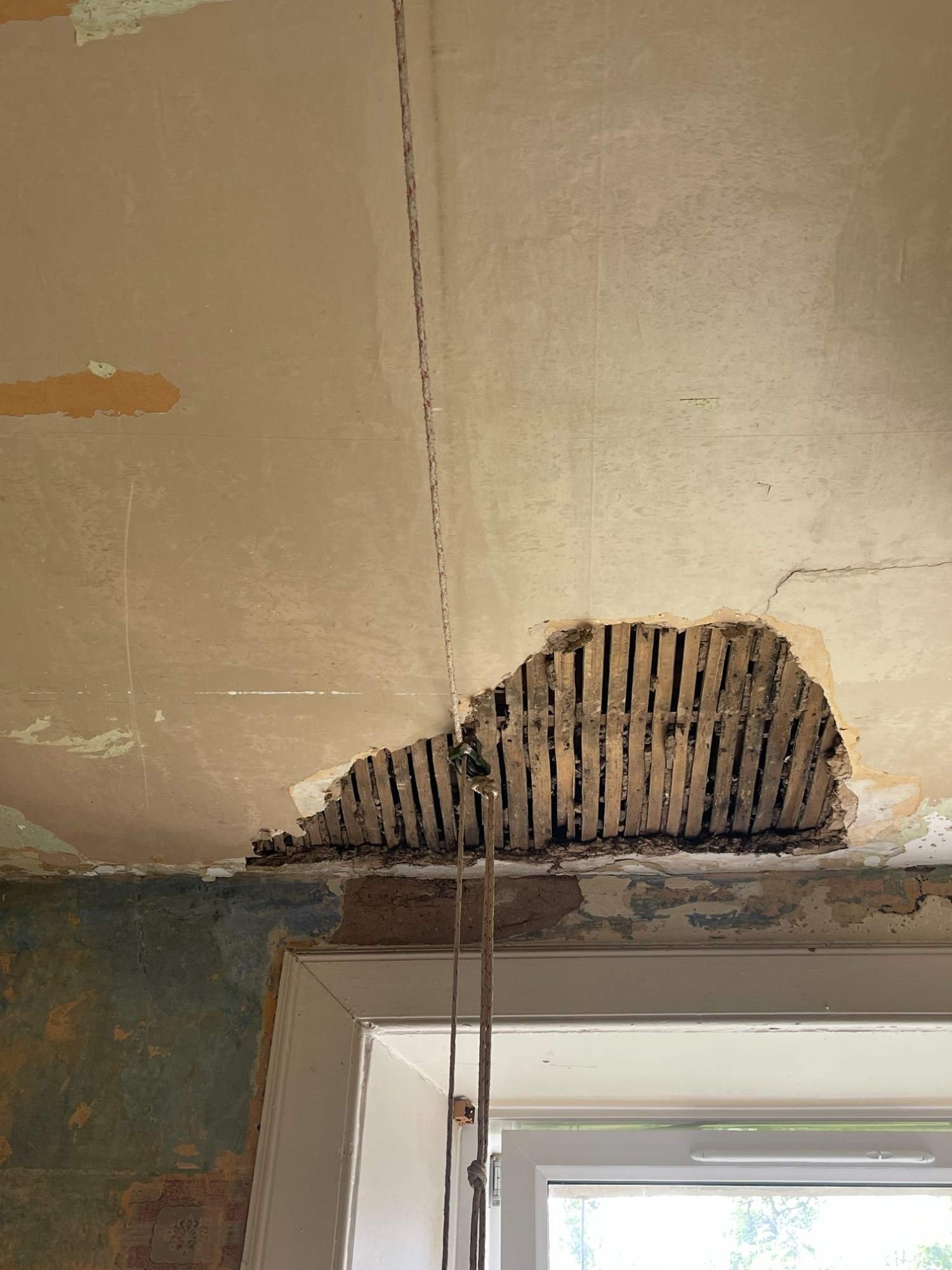 Damaged kitchen ceiling with holes and loose plaster exposed during strip-out, Marchmont flat, Edinburgh